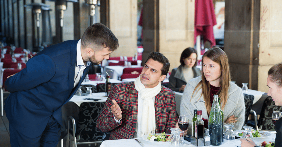 Restaurant guest voicing a complaint to a manager during dining service.