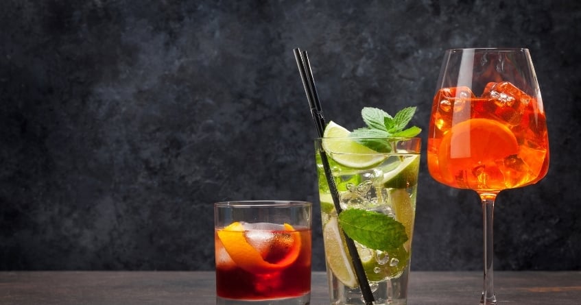 Assorted cocktails served in a rocks glass, highball, and wine glass — showcasing how glass shape influences presentation, color, and guest perception.