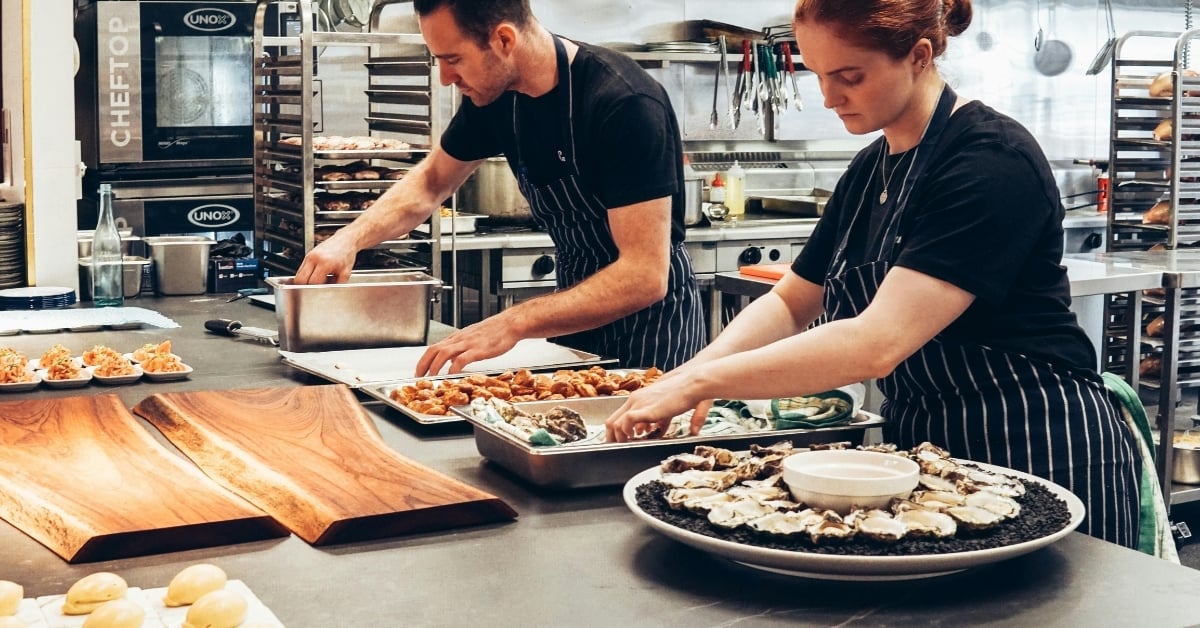 Chefs preparing fresh seafood and appetizers in commercial kitchen.”