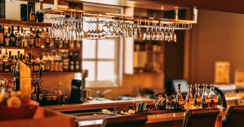 Well-stocked bar with liquor inventory and glassware organized for service efficiency.