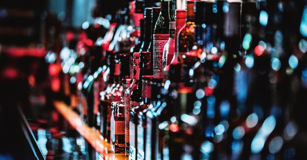 Liquor inventory on bar shelves with various spirits organized for tracking and control