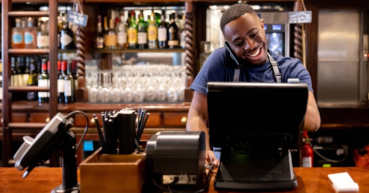 Bartender using POS system for restaurant menu pricing technology