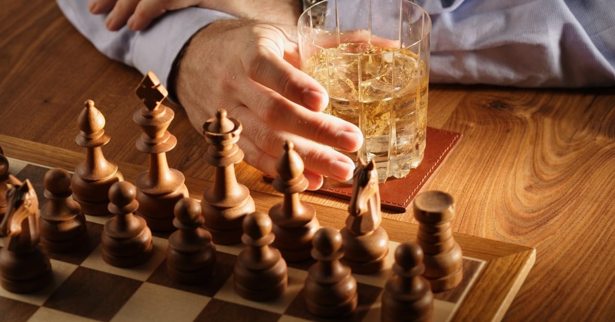 Close-up of a chessboard with a glass of whiskey, symbolizing bar strategy, profit planning, and smart decision-making