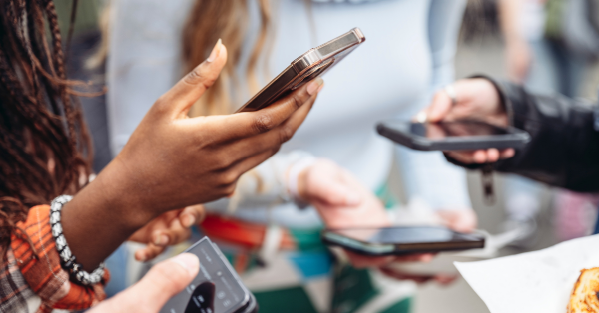 Close-up of people holding smartphones, highlighting social media, customer feedback, and digital engagement in the restaurant industry.