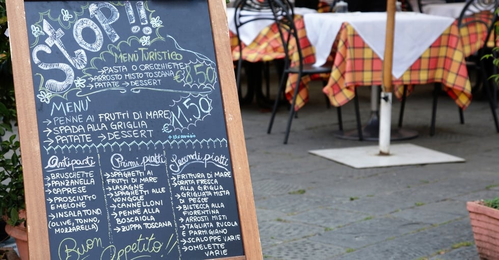 Chalkboard menu outside a restaurant with handwritten food options.