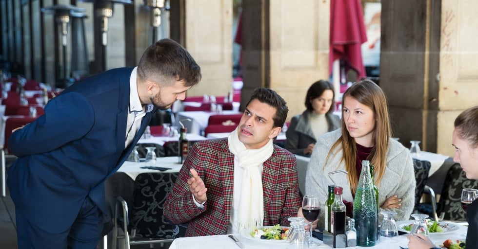 Restaurant guest voicing a complaint to a manager during dining service.