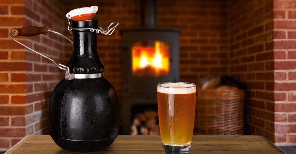 Beer growler and pint glass near warm fireplace, highlighting storage risks for draft beer