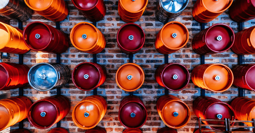 Beer kegs stored on wall racks in brewery for efficient keg rotation and storage"