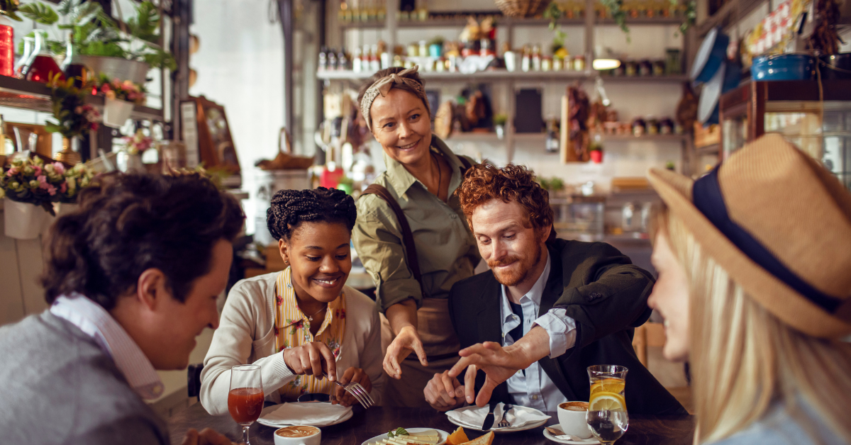 Smiling server assisting guests during a dining experience in a restaurant.