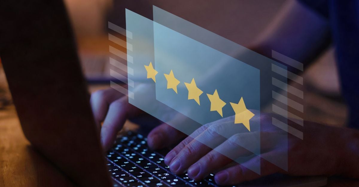 Hands typing on laptop with five-star review graphic overlay, symbolizing online reputation and customer satisfaction.