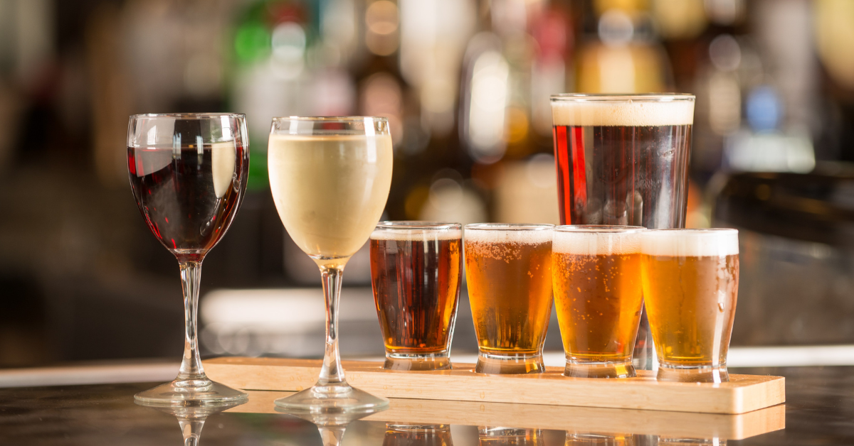 Assorted beer flight and wine glasses lined up at a bar — tracking sales by beverage type helps with inventory planning and identifying high-margin items.